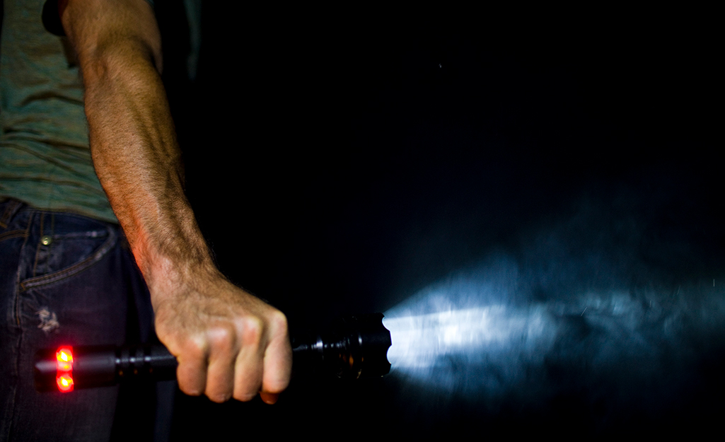 A man holding a flashlight in the dark. A man holding a flashlight in the dark.