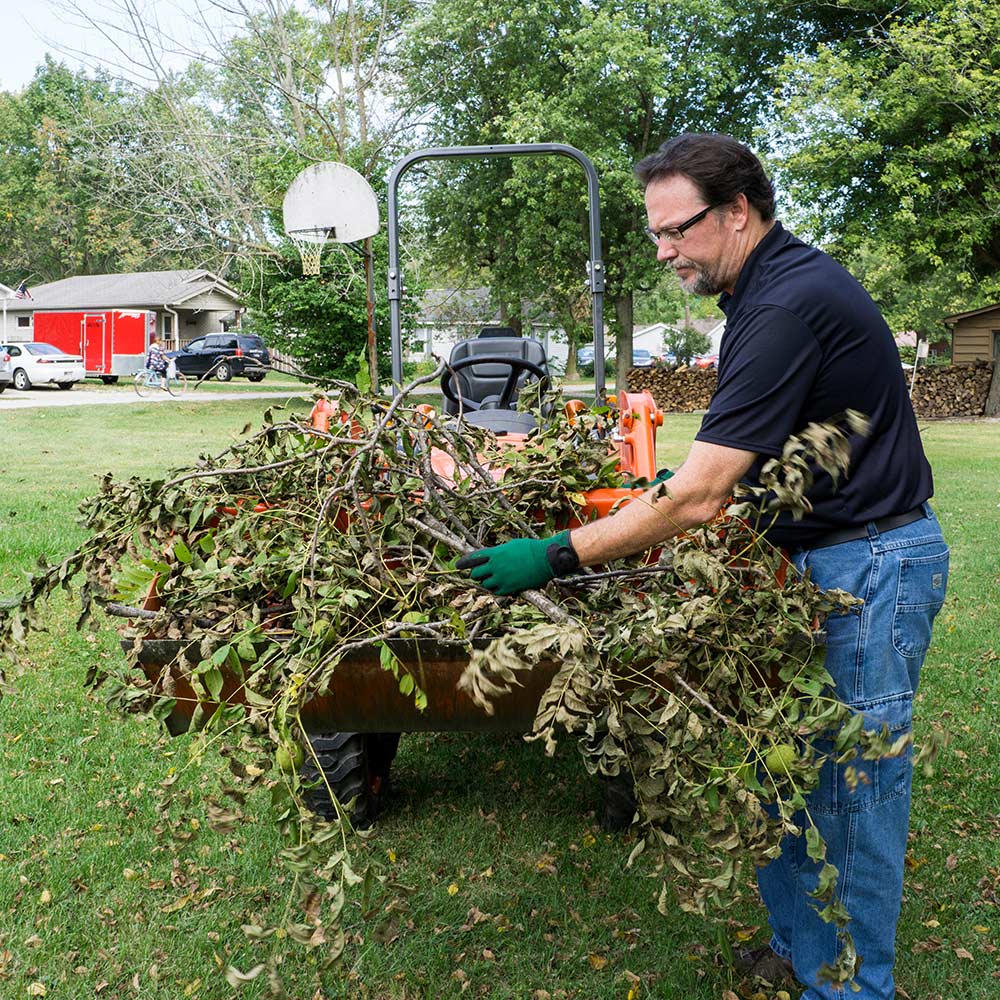 Homeowner cleaning up yard rubbish. Homeowner cleaning up yard rubbish.