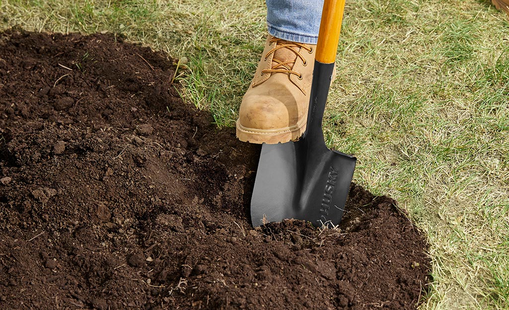 Gardener digging flower bed