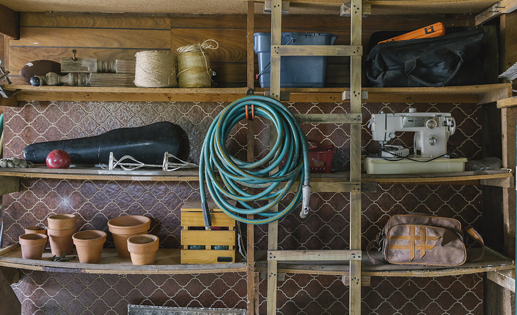 A hose rolled and hung up in an indoor storage space.