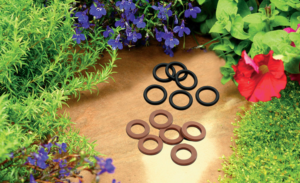 A collection of washers on a table surrounded by plants.