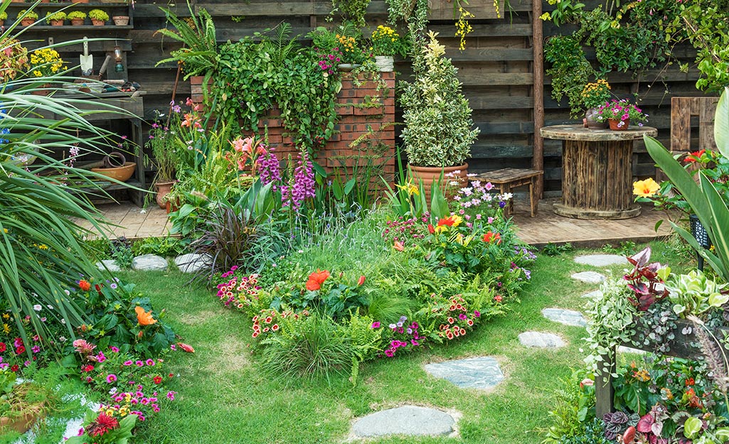 A garden with flowers in ground and in containers