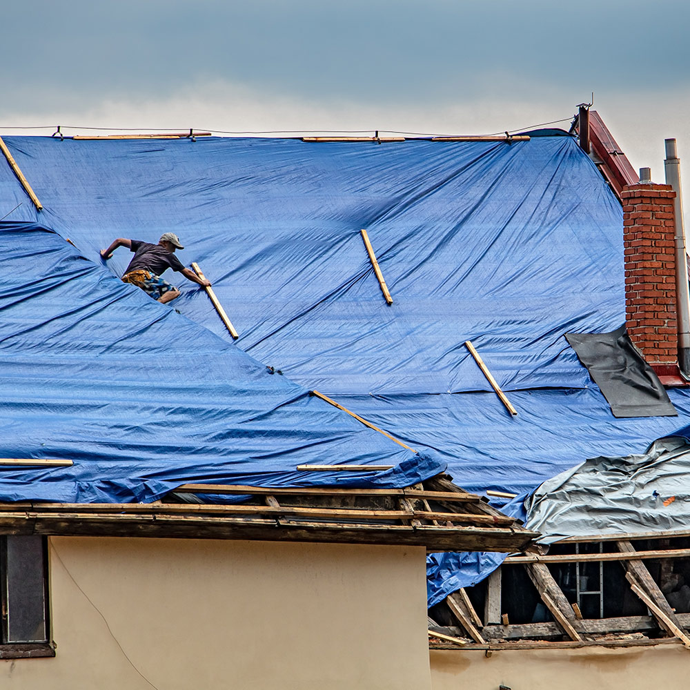 A blue tarp on a roof. A blue tarp on a roof.
