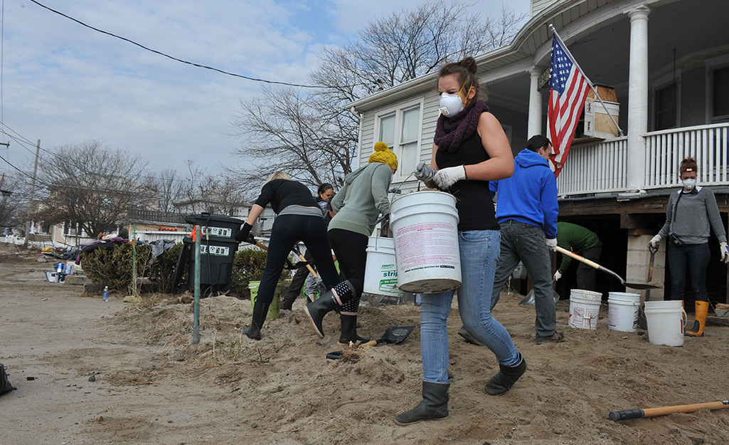People cleaning up an area after a storm. People cleaning up an area after a storm.