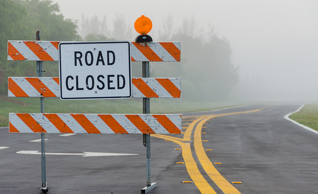 Smoke rising up behind a road closed sign Smoke rising up behind a road closed sign