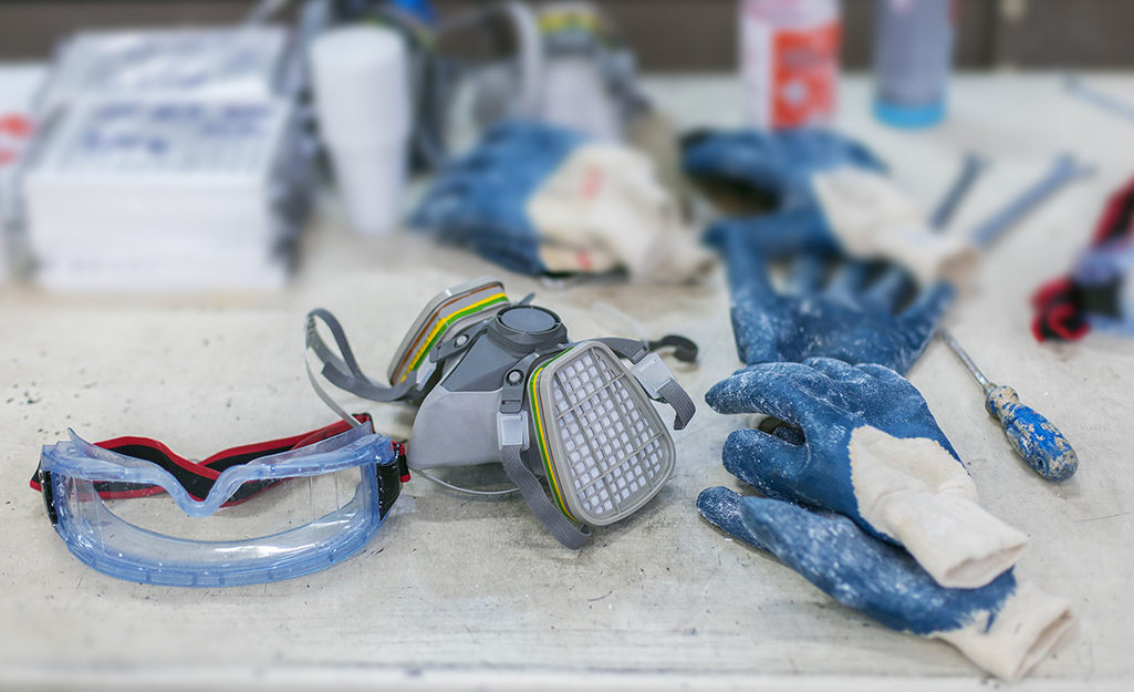 A respirator mask, work gloves and other floor finishing equipment.