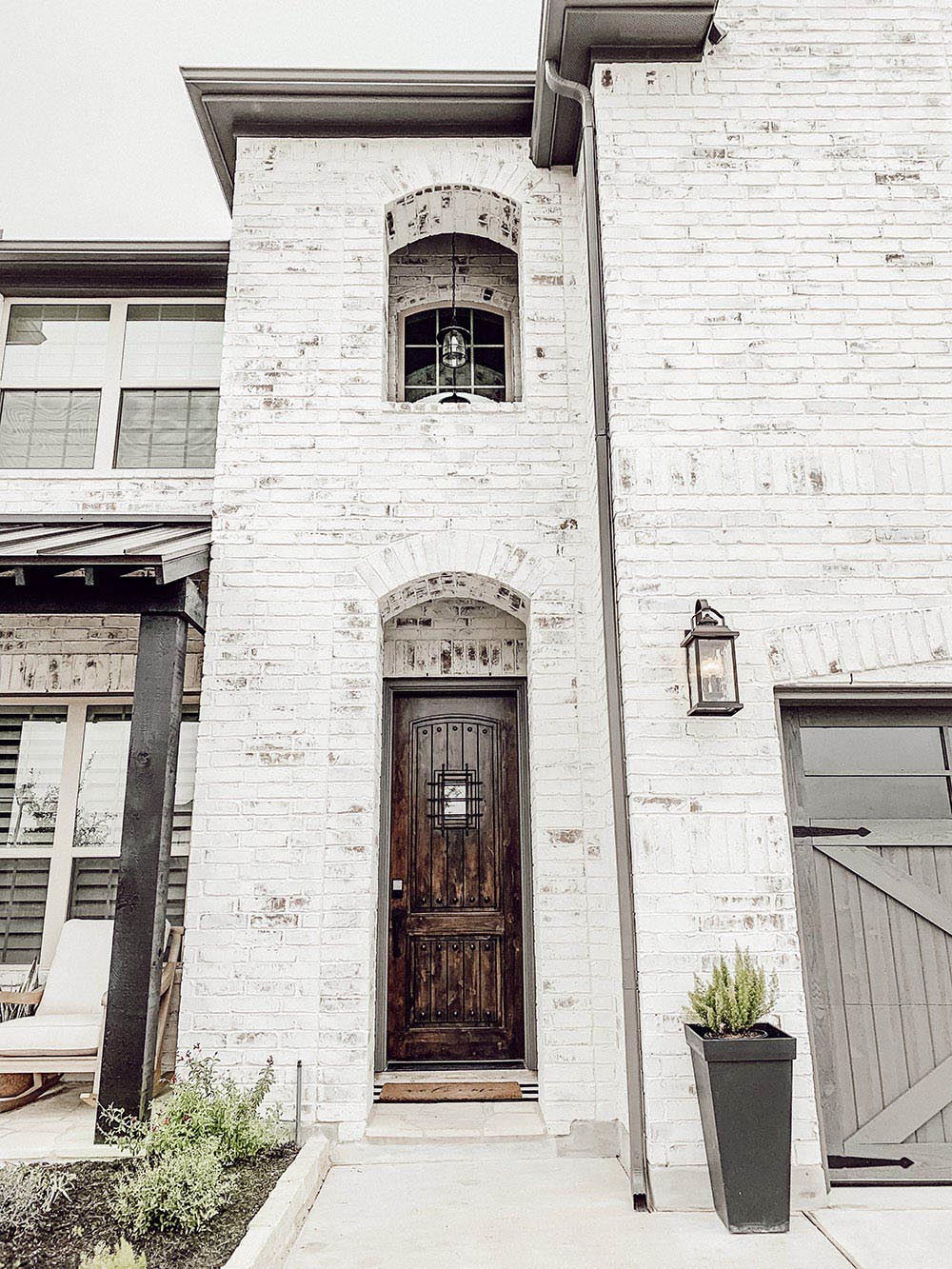 A white brick home with a dark wooden front door.