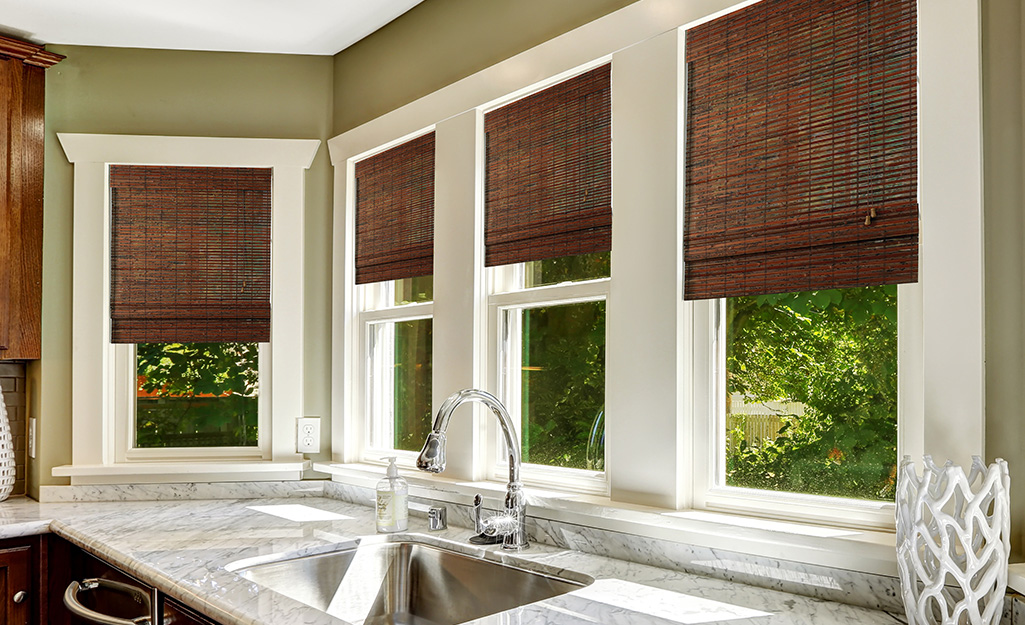 Kitchen windows featuring wood blinds.