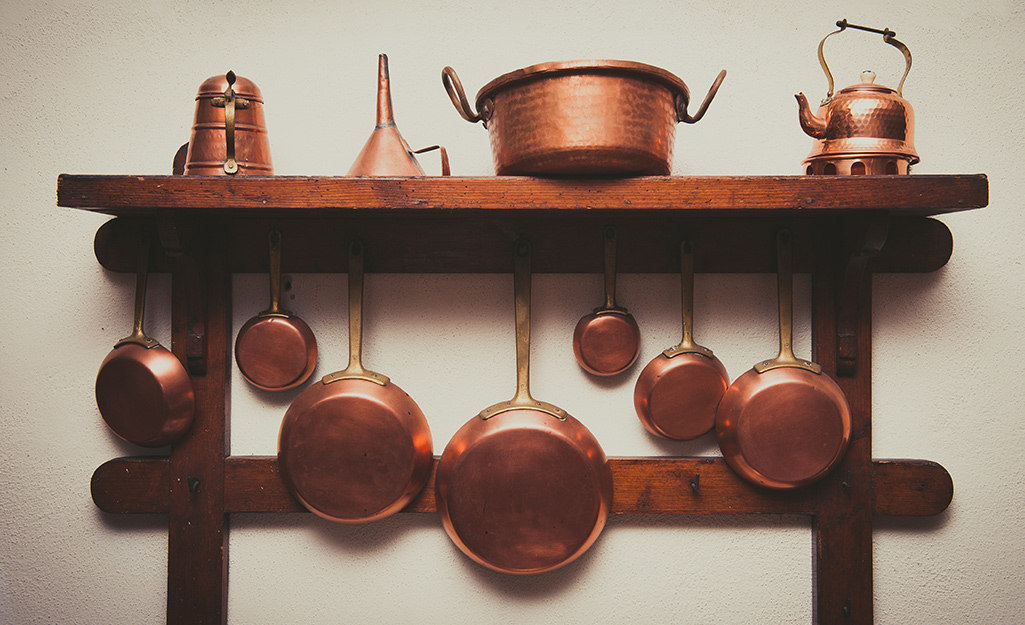 A collection of copper pots displayed on a shelf.