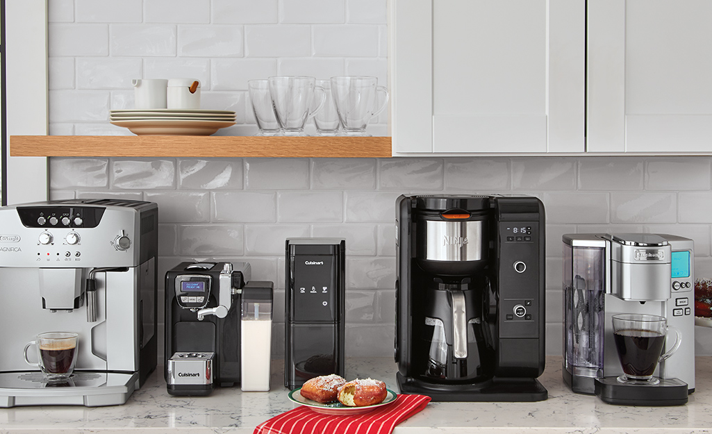 Several small coffee and tea appliances placed on a counter.