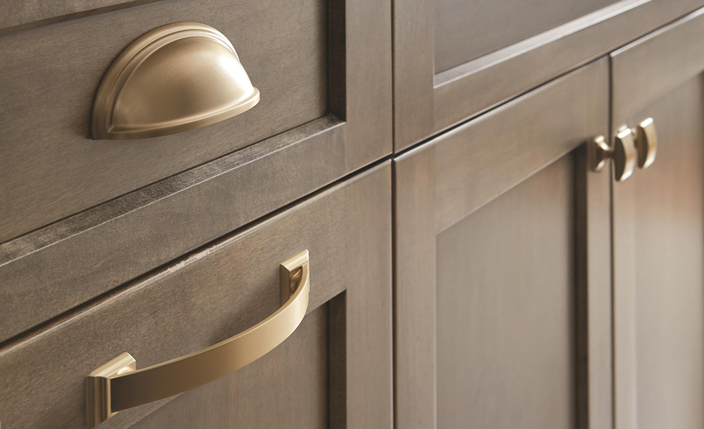 Brushed silver hardware added to a gray kitchen cabinet.