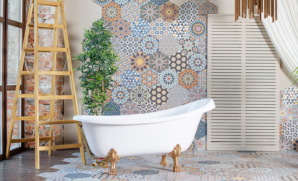 A designer bathtub sitting in front of bold wallpaper.