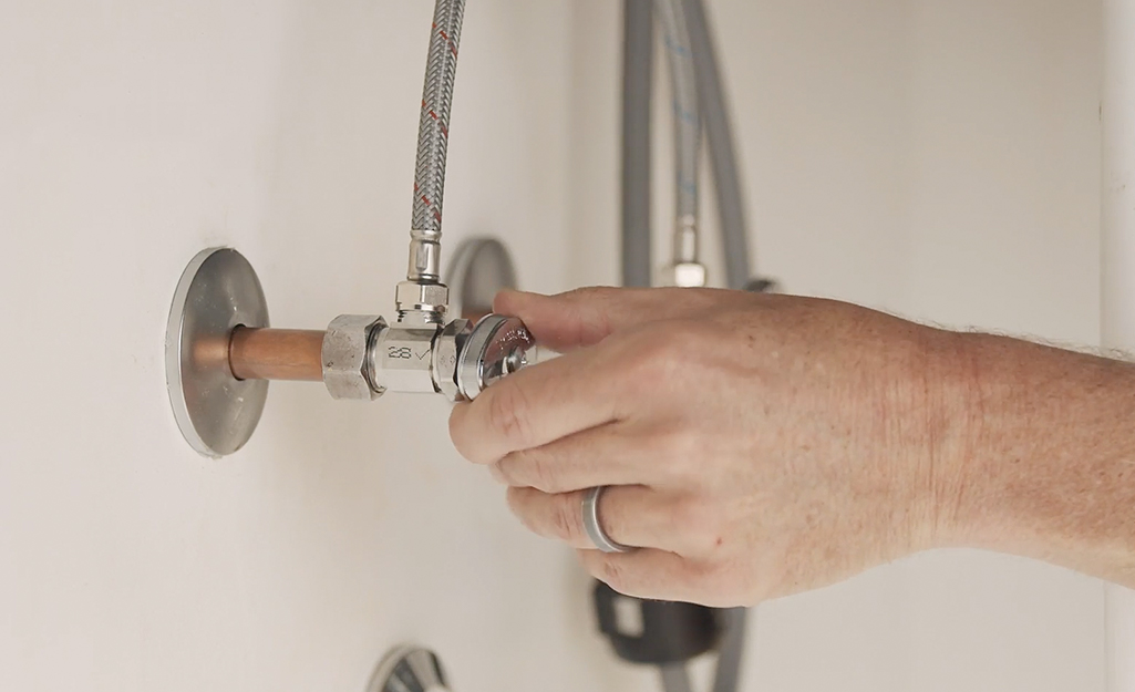 Someone turning off water supply to kitchen sink.