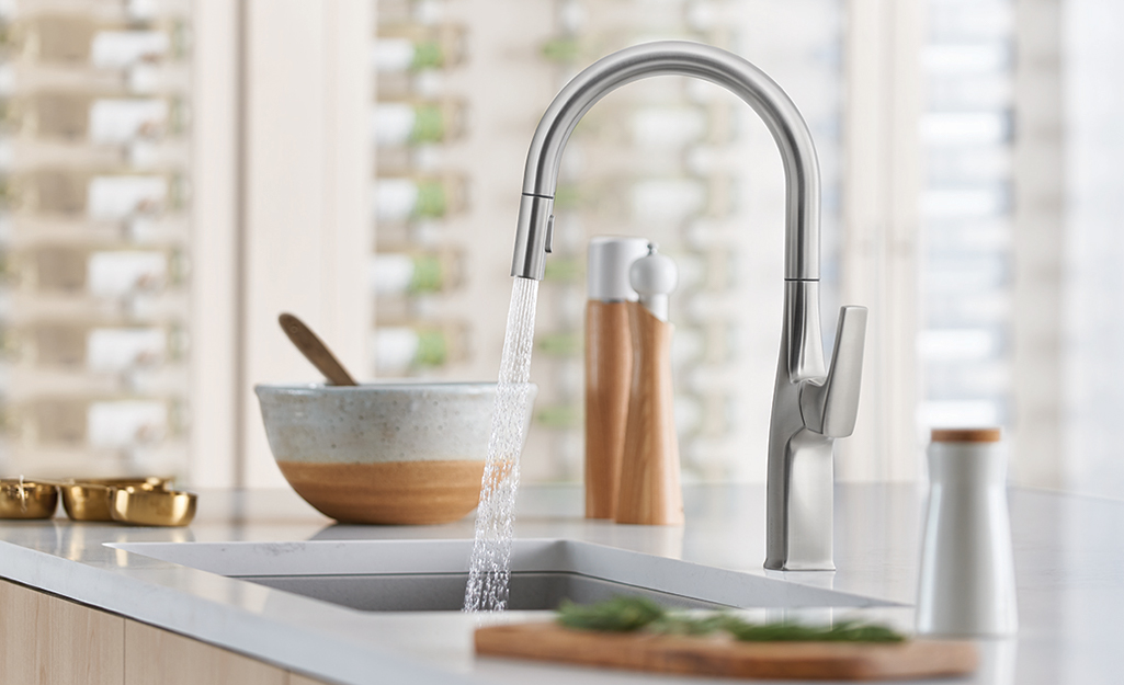 Water spraying out of a kitchen faucet.