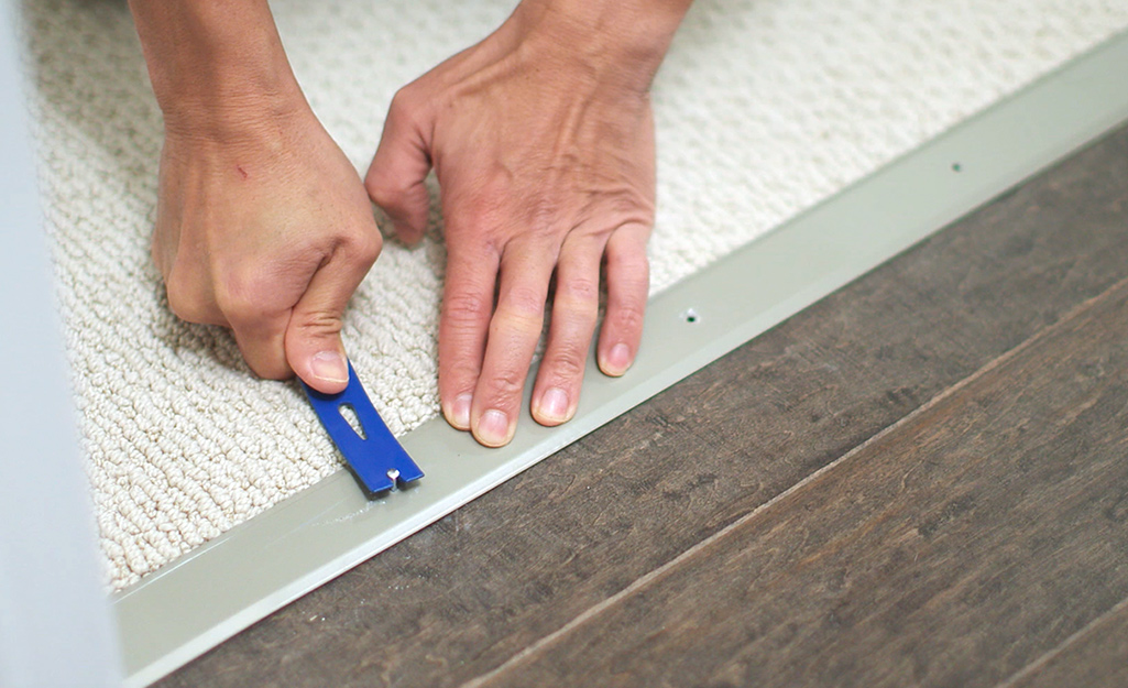 A person removing the nails of an interior threshold.