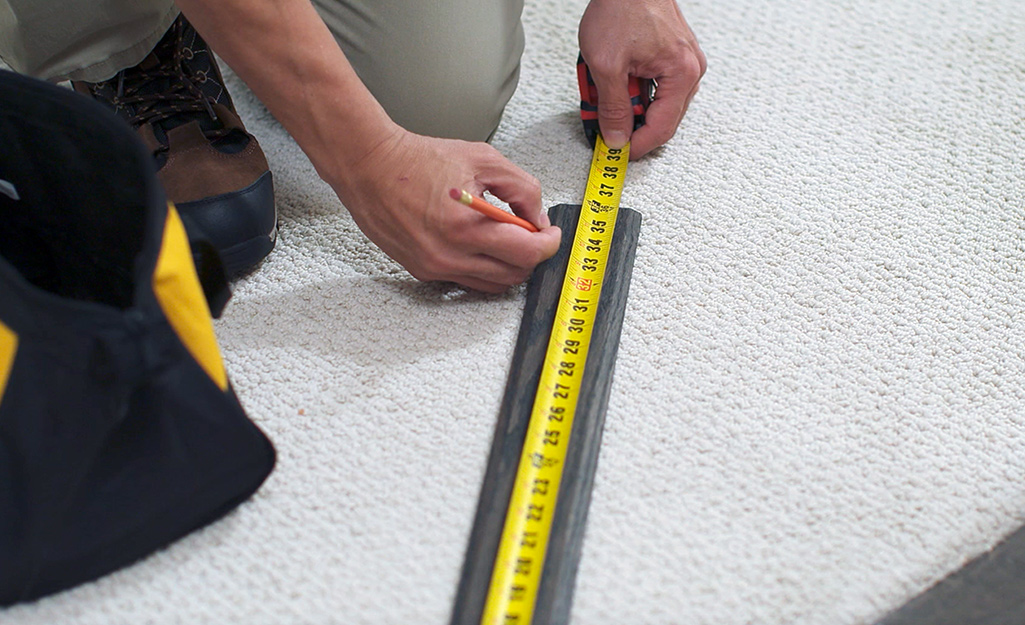 A person measures the new threshold.