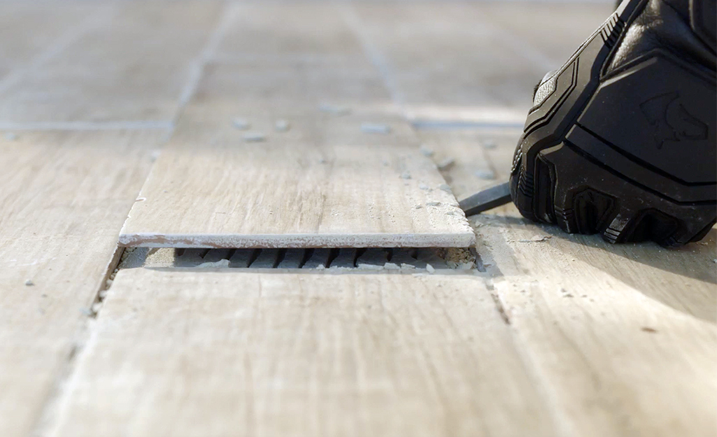 Someone prying up old ceramic flooring.