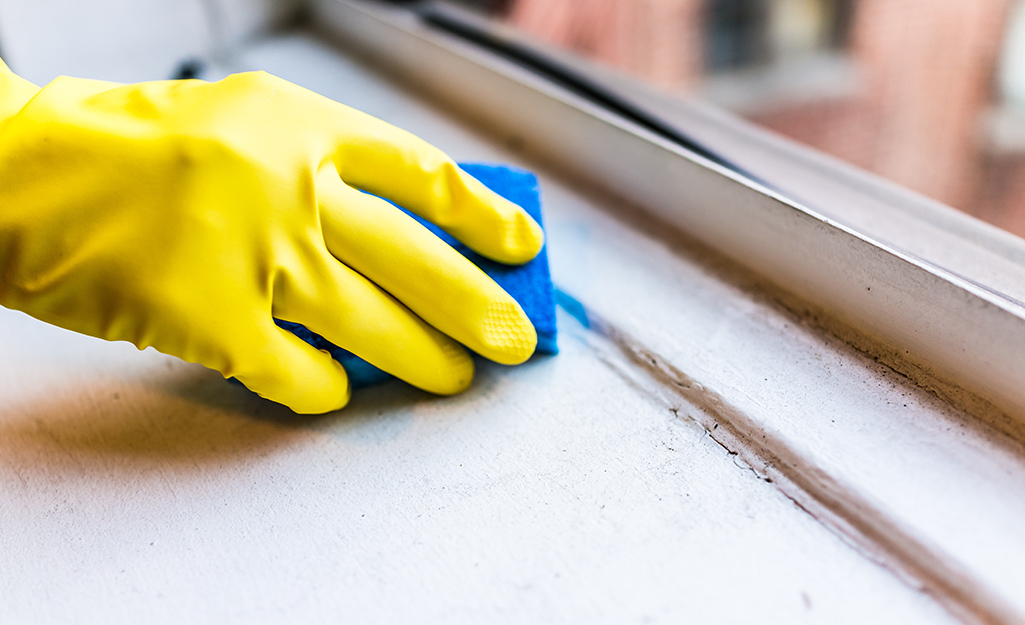 Person cleans a window sill.