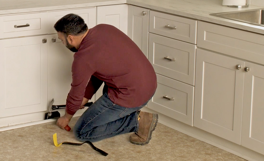 A person removing baseboards.