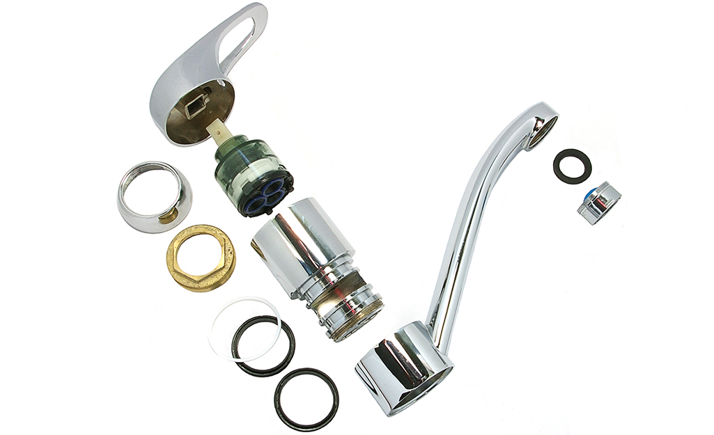 A disassembled single-handle faucet showing the inside parts in order.