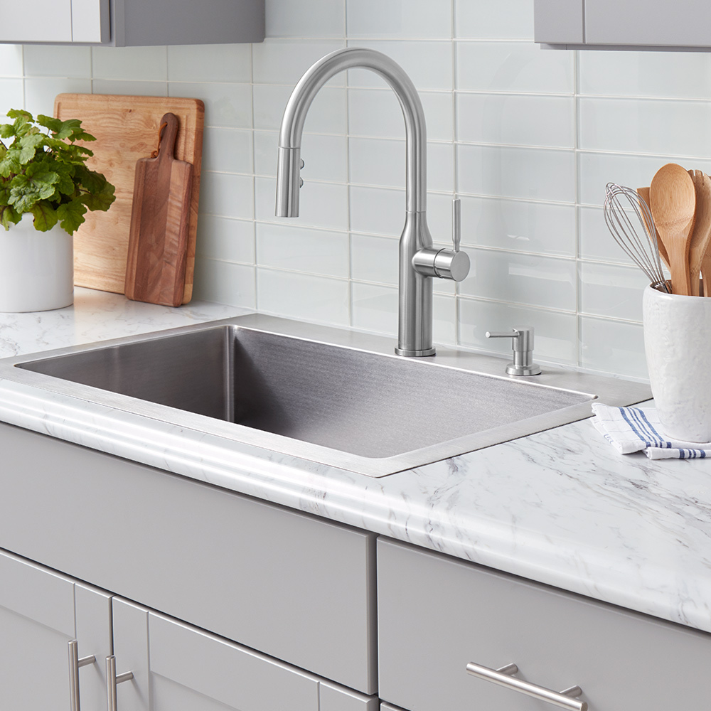 An undermount kitchen sink with silver faucet.
