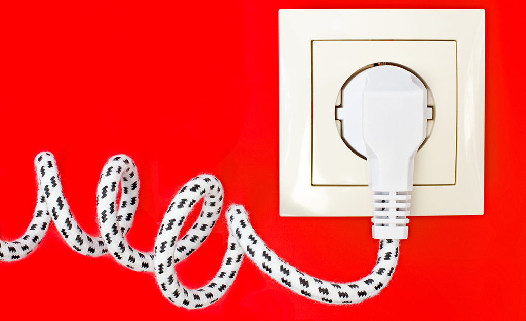 A fabric-covered power cord plugged into an outlet.