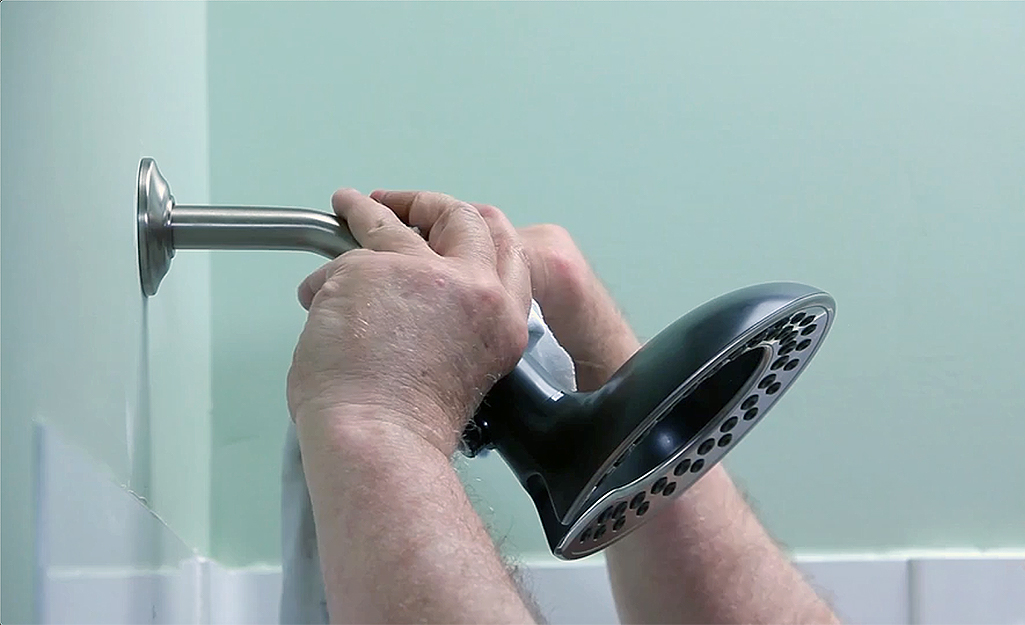 A person installing a shower head.