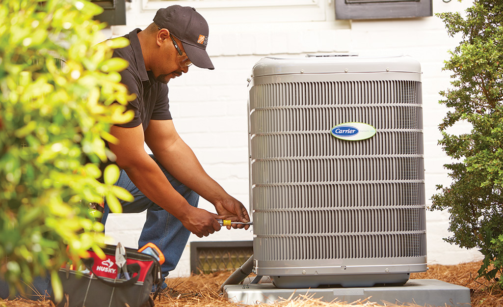 A Home Depot associate repairing an air conditioning unit.