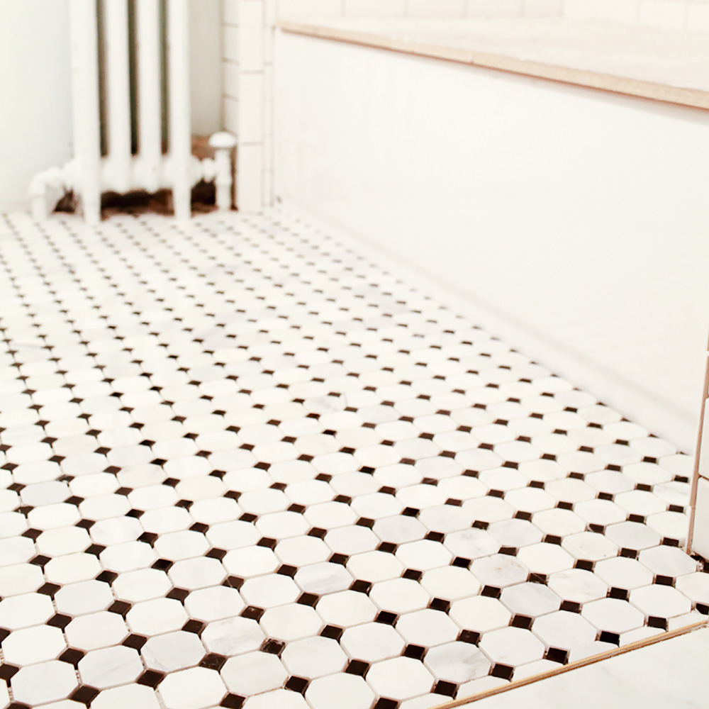 A white and black tiled bathroom floor.