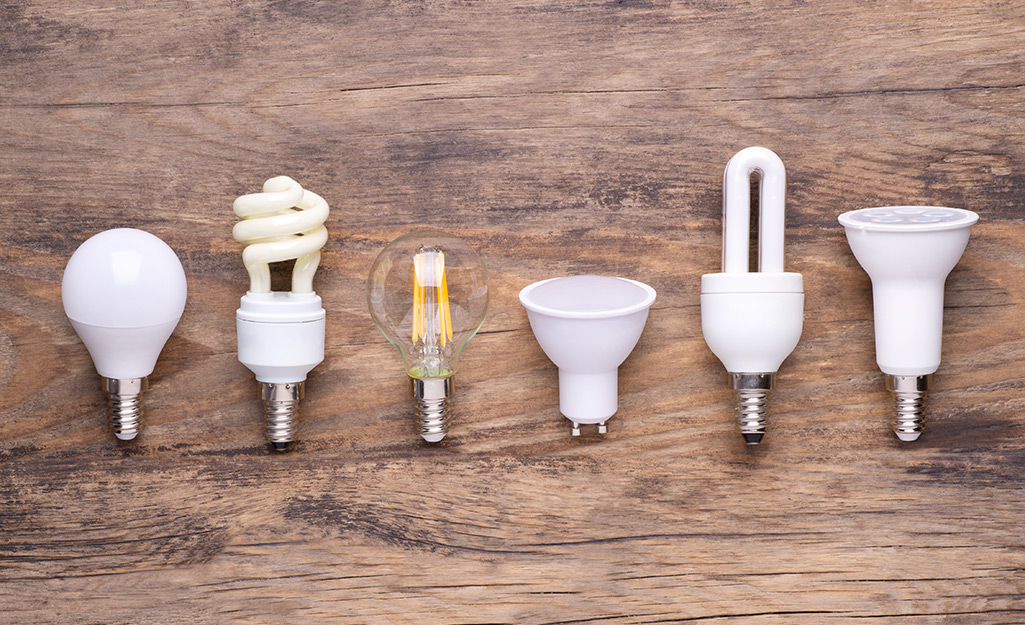 Six various energy-saving bulbs sit on a table.