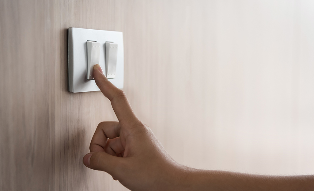 A person turning off a switch. 