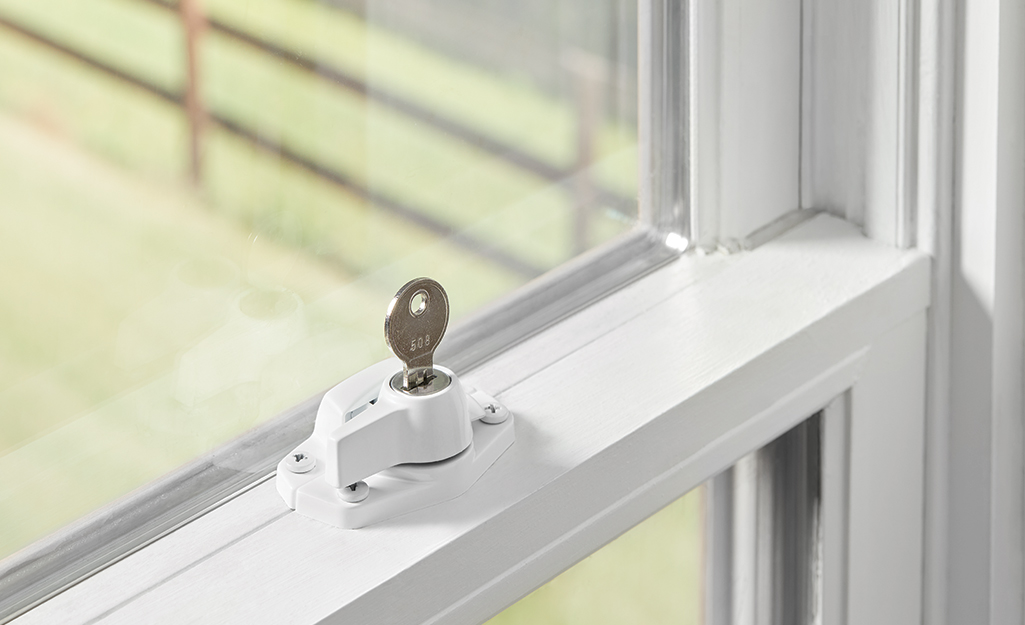 A key stands upright in a window lock.