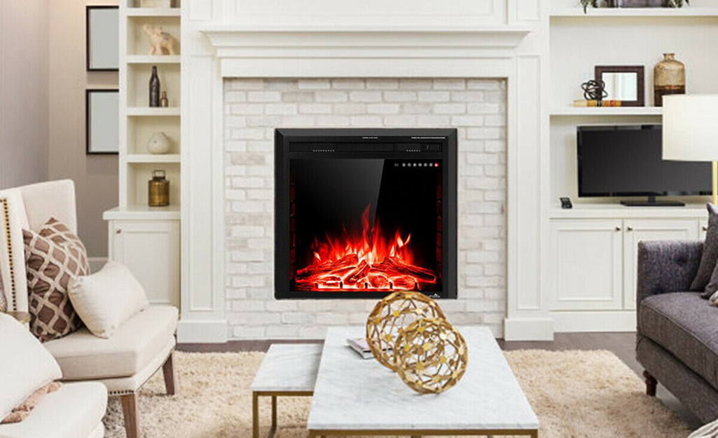 Red flames glow inside an electric fireplace insert in a living room.