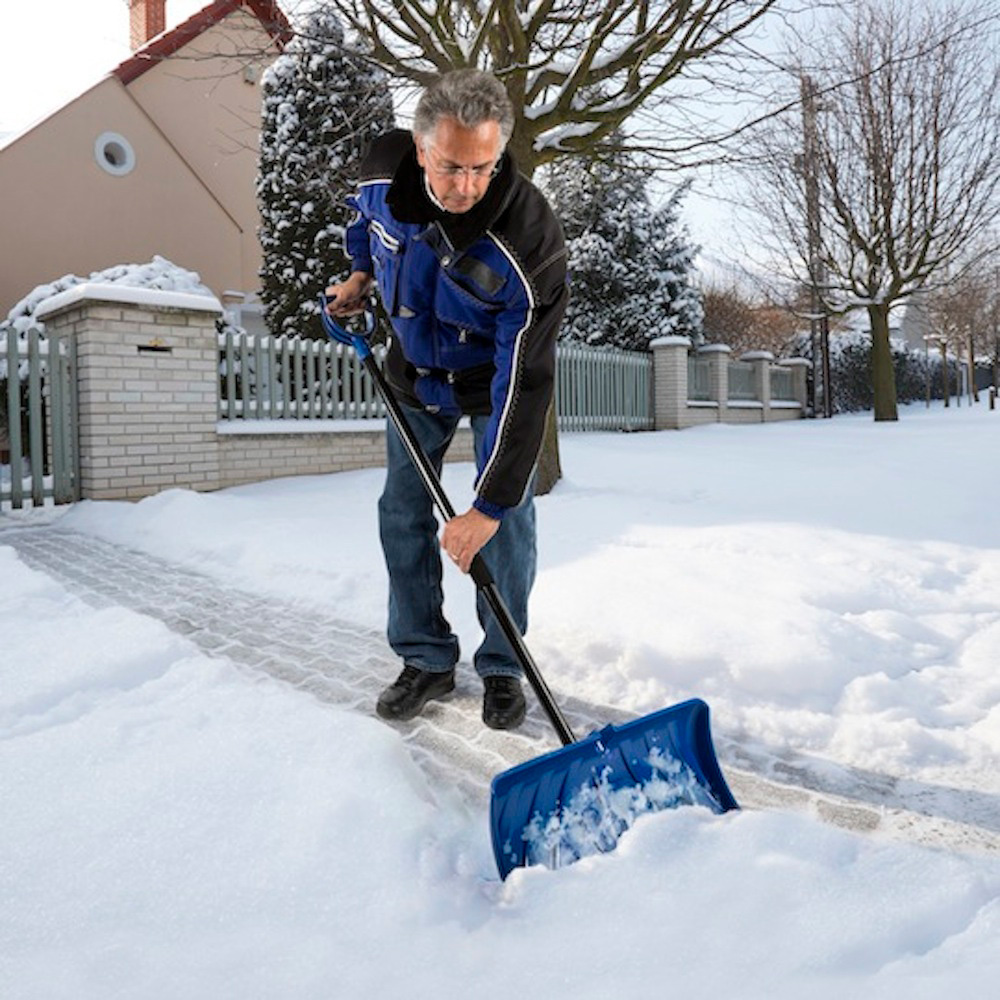 A person shoveling snow in a driveway.