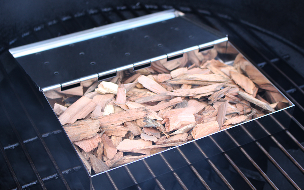 A tray of wood chips prepares a smoker for cooking. A tray of wood chips prepares a smoker for cooking.