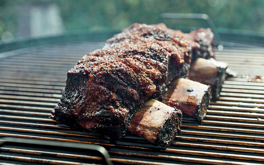 Beef ribs cook on a smoker. Beef ribs cook on a smoker.