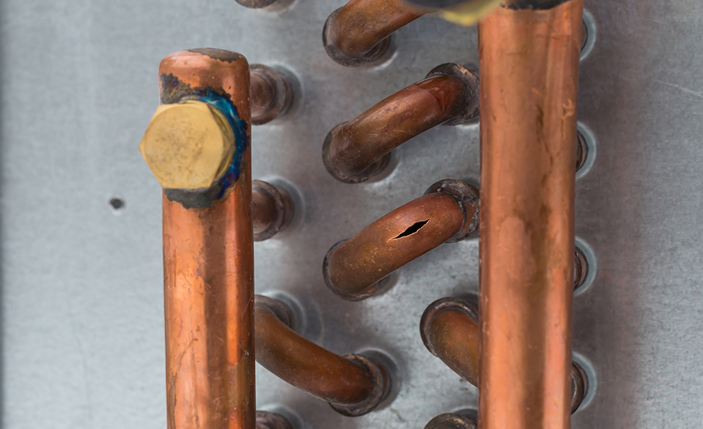 A hole in a copper pipe needs repair.