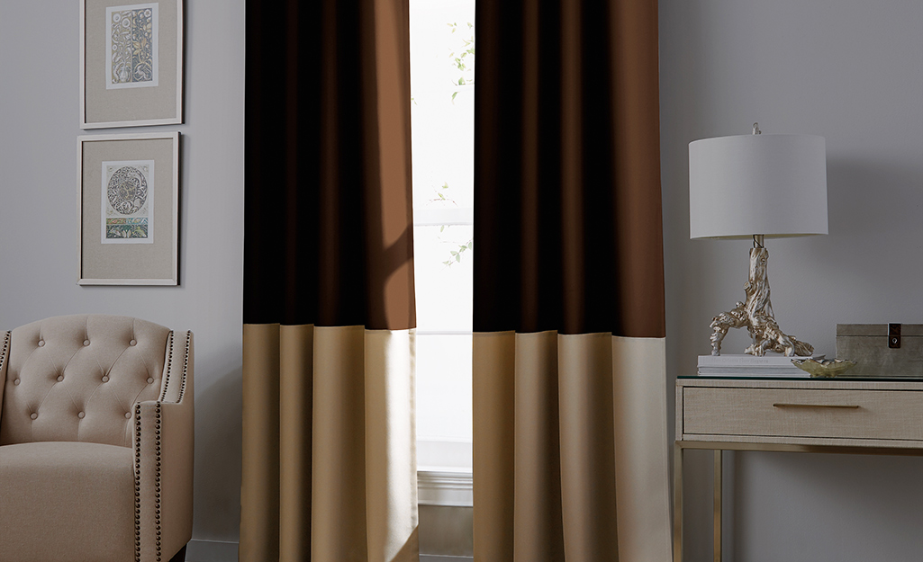 A living room window is soundproofed with heavy blackout curtains.