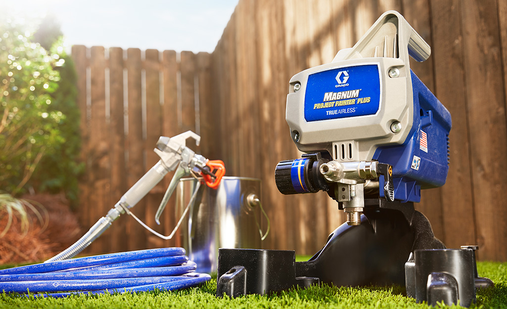 An airless paint sprayer sitting in grass.