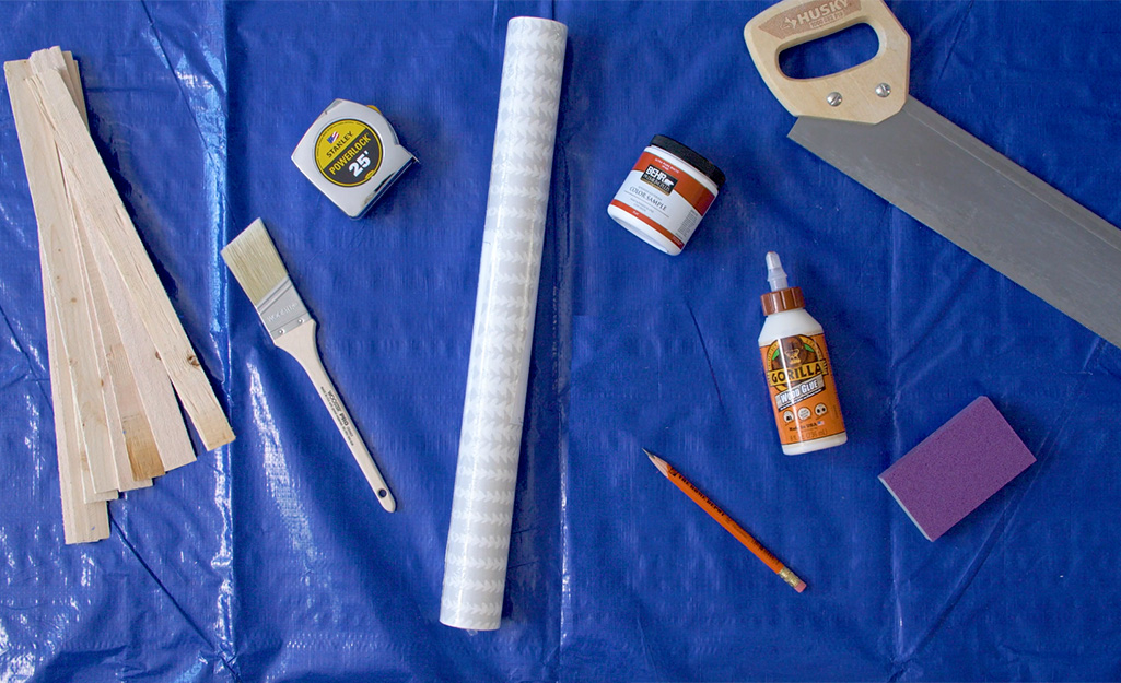 Wood shims, tape measure, a saw and other supplies lay on a tarp.