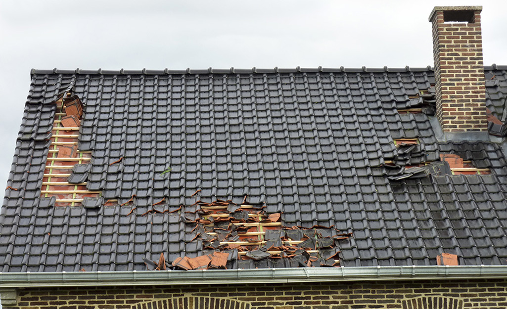 A roof with damage to the shingles in multiple areas