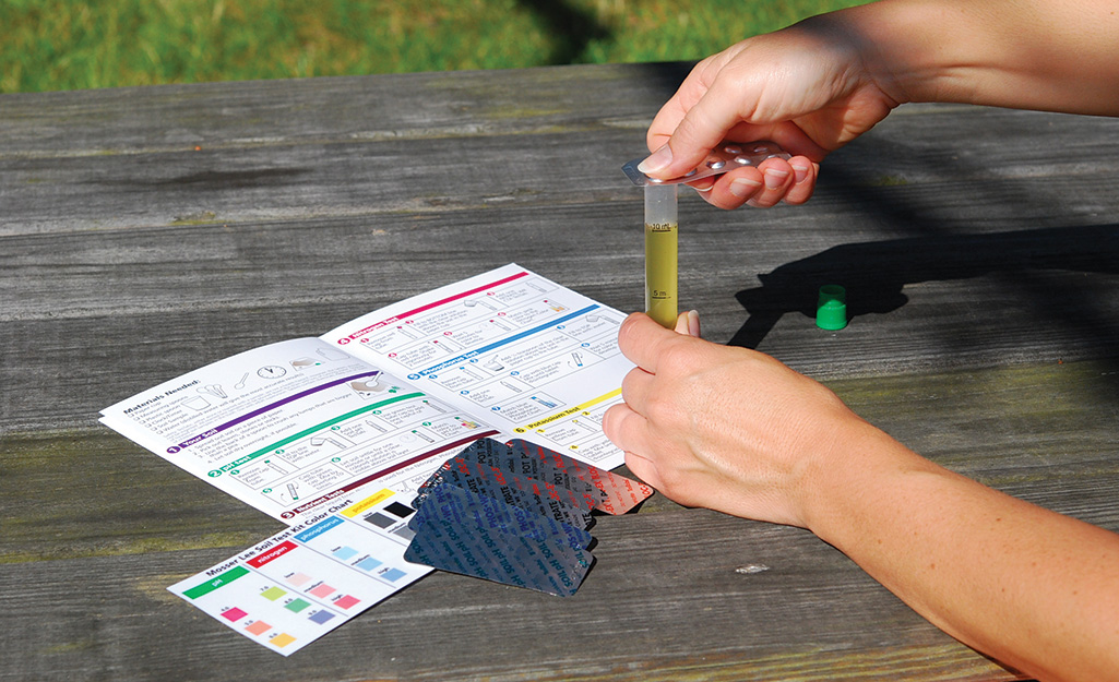 Person using a soil test kit.