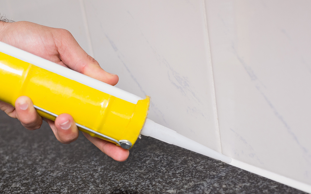 A person applying grout for shower tile installation. A person applying grout for shower tile installation.