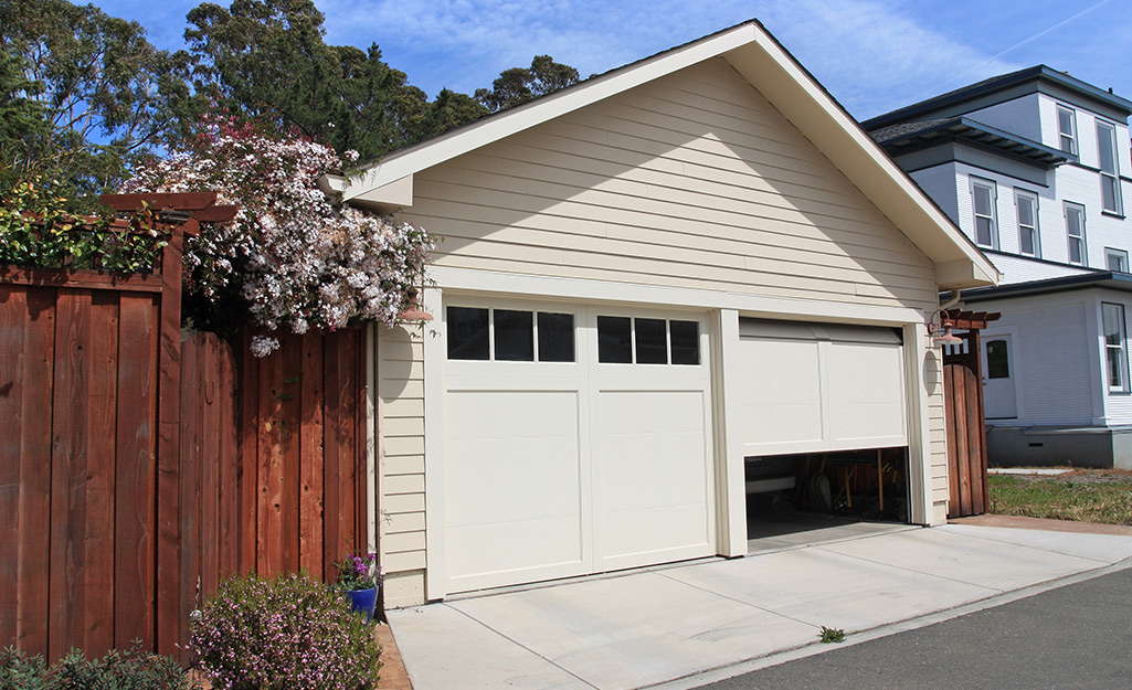 A garage with its door halfway between the open and closed position.