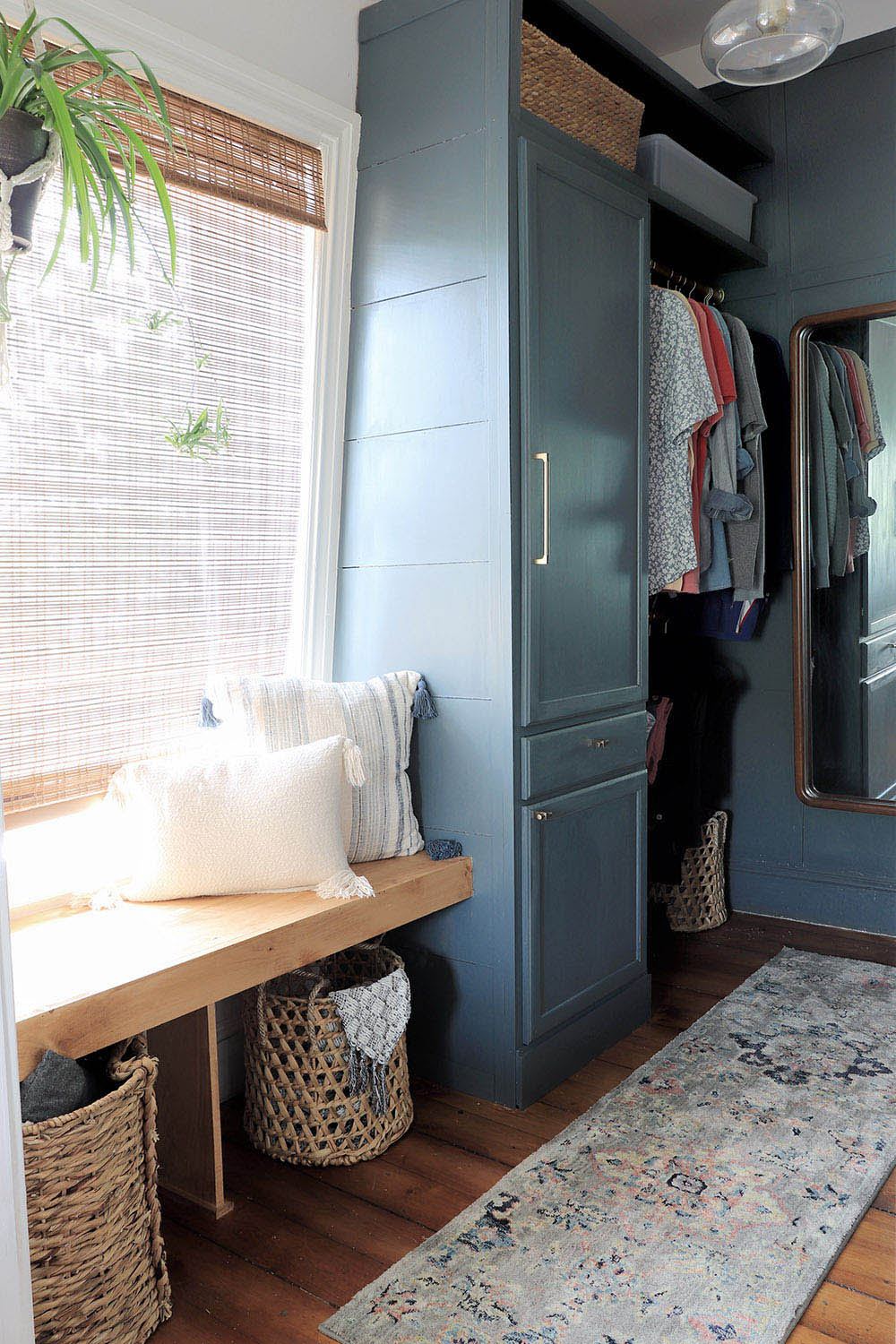 A closet with pillows on the bench and a rug on the floor