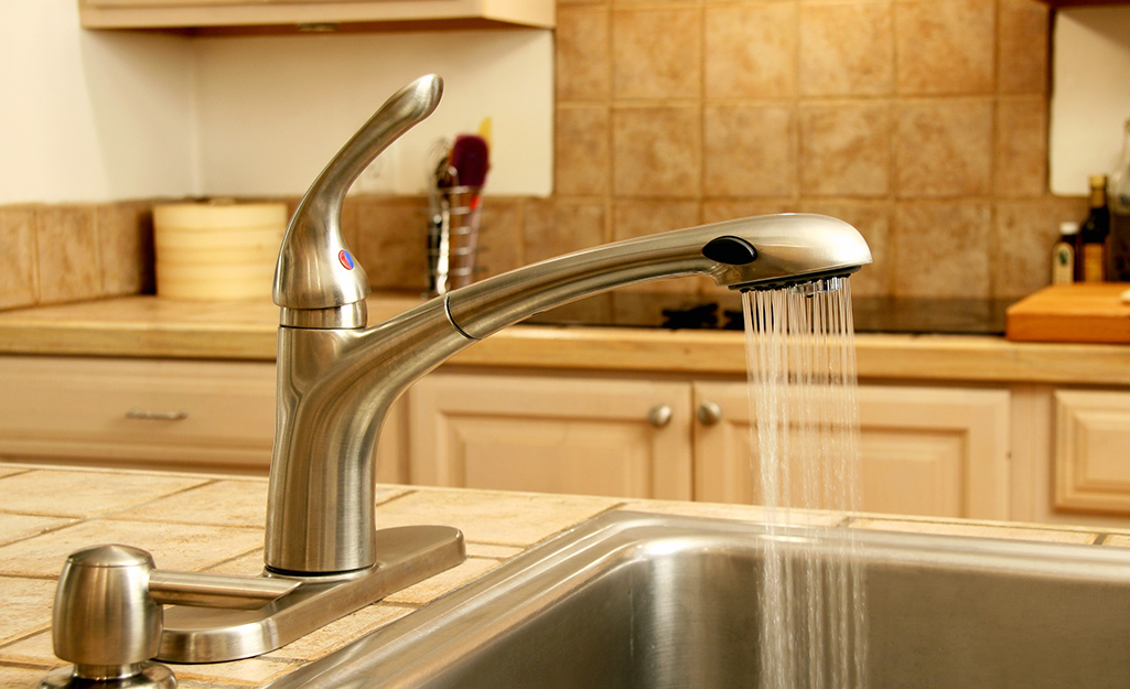 L'eau coule d'un robinet dans un évier de cuisine.