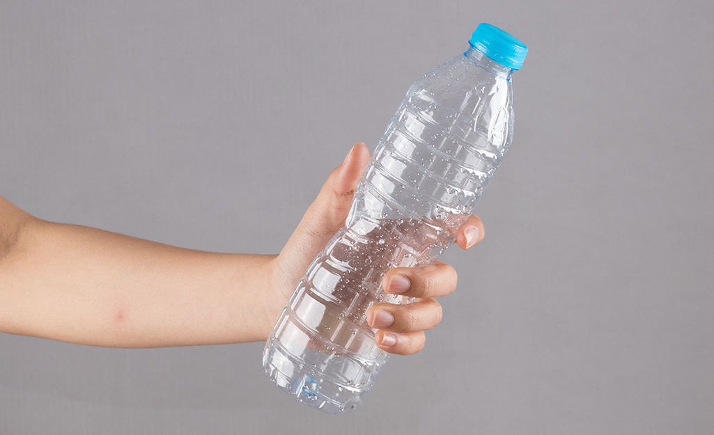 A person holding a clear plastic bottle.