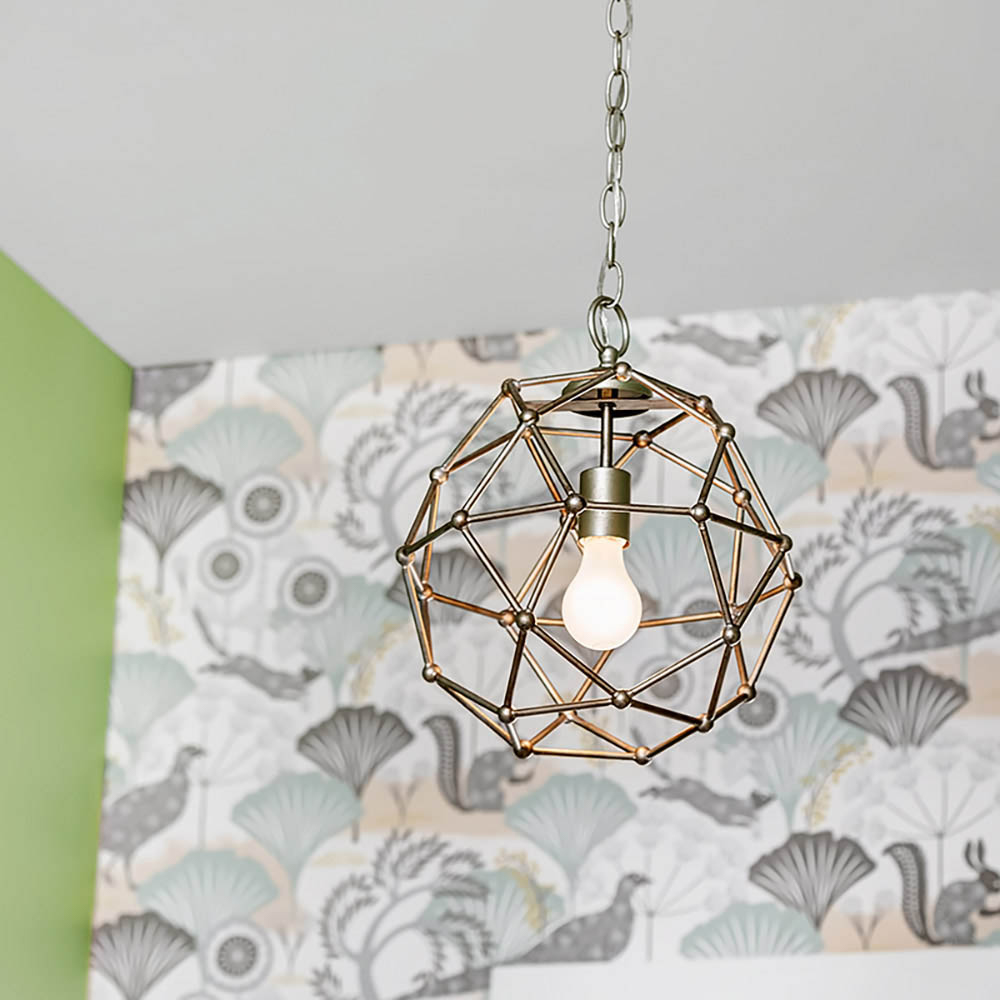 A light fixture hangs from a ceiling in front of a floral wall.