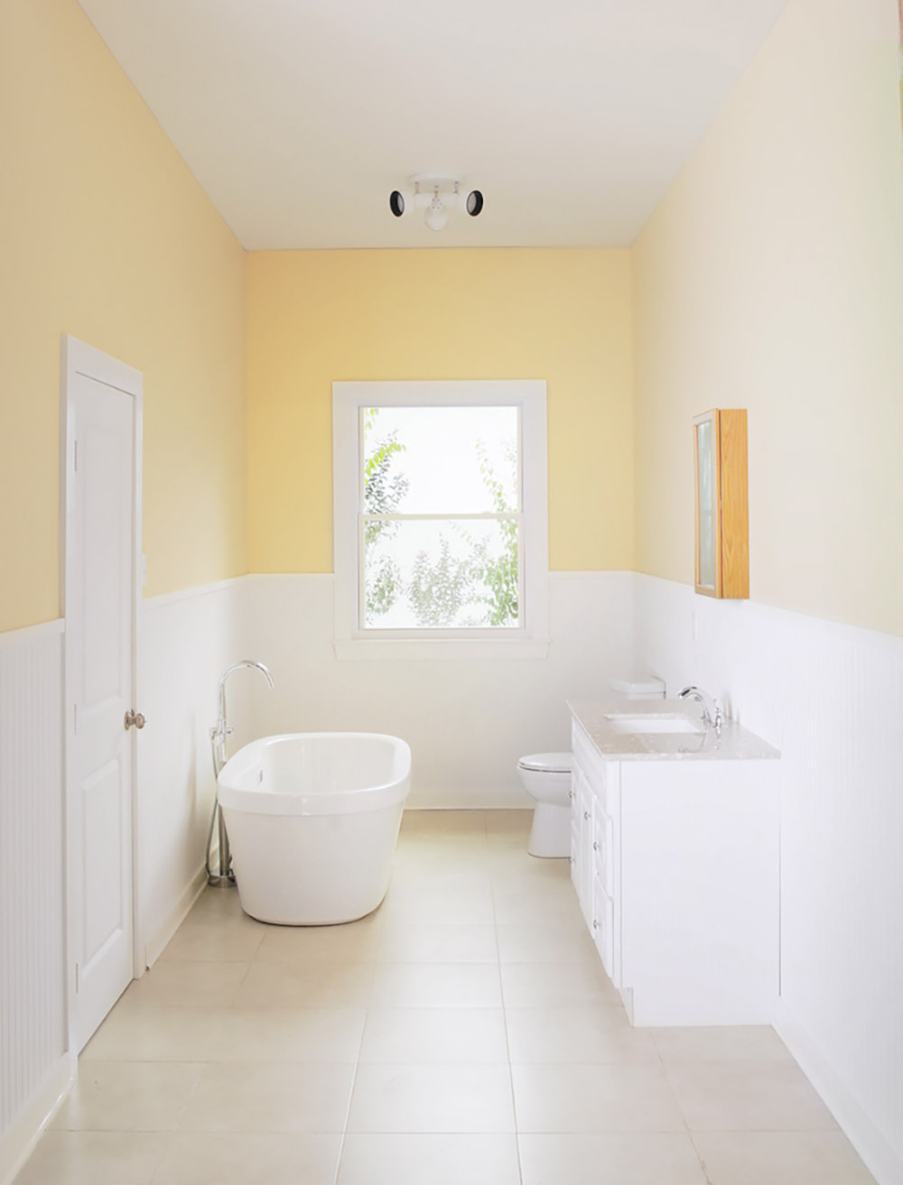 An undecorated white and yellow bathroom.