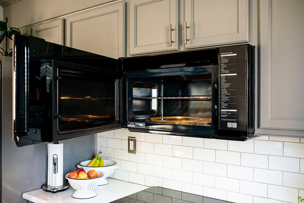 A Samsung over-the-range microwave with the door open.